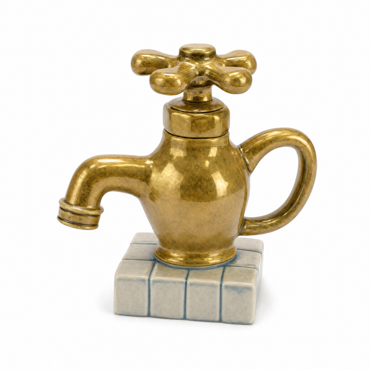 Tap Teapot in gold: a ceramic brass bib tap with a cross-handle lid standing on a small tiled base